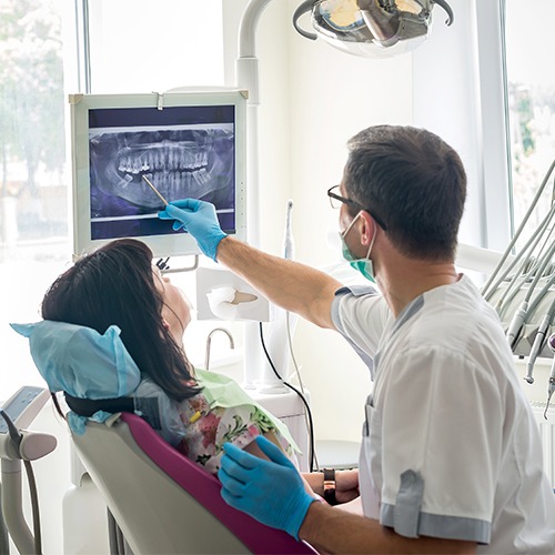 Dentist and patient looking at digital x-rays