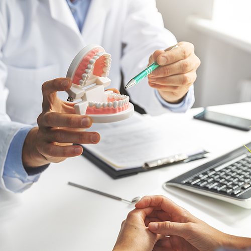 Periodontist pointing to smile model