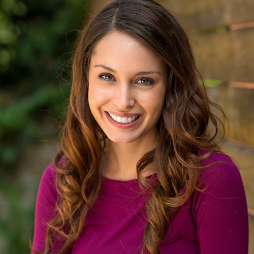 A woman smiling outside.