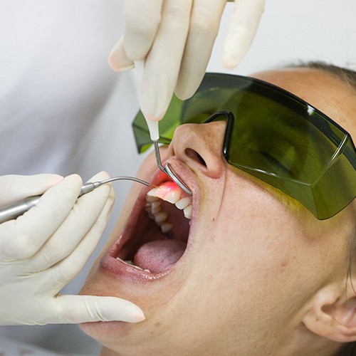 A woman receiving soft tissue laser treatment.