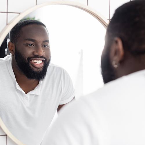 Man admiring his smile after gum grafting procedure