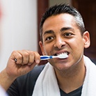 Man brushing his dental implants in Huntington Beach