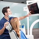 Huntington Beach implant dentist reviewing dental X-rays with patient