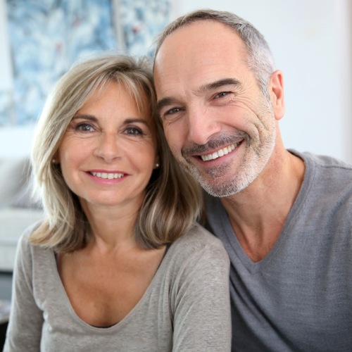 Smiling older man and woman sitting in living room