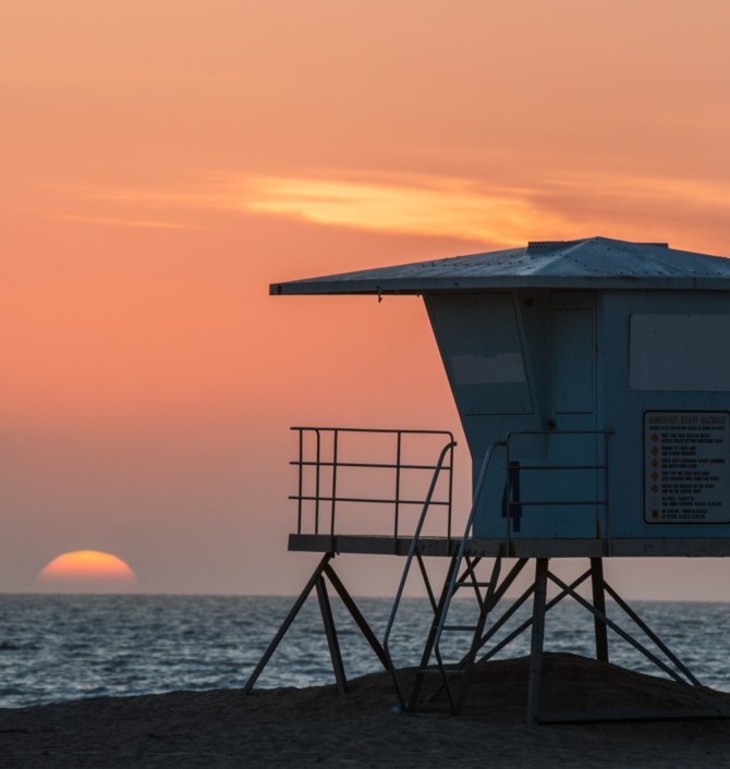 Lifeguard stand on beach at sunset