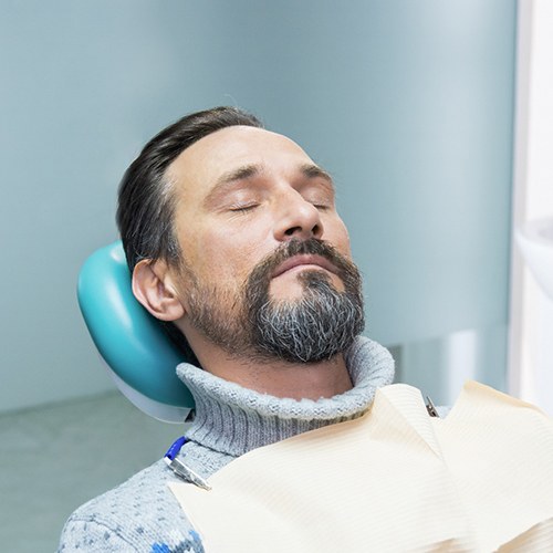 Older man in dental chair under effects of oral conscious sedation in Huntington Beach, CA