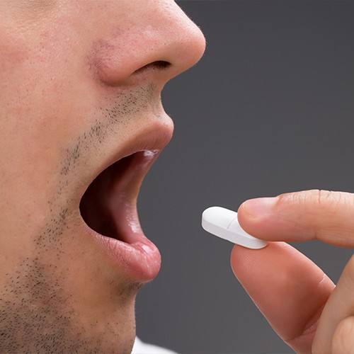 Man taking oral sedative pill