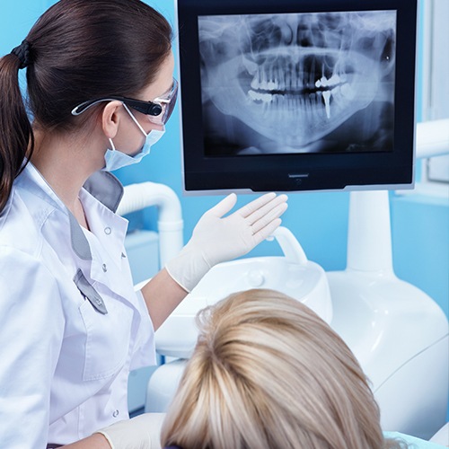 Team member and patient looking at digital x-rays