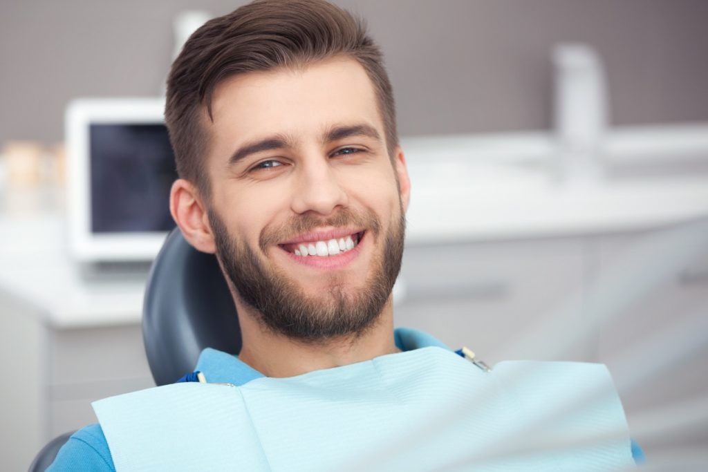 Smiling man at the dentist after getting gum disease treatment 