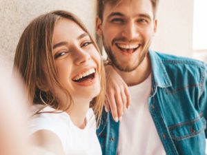 Man and woman smile after seeing their Huntington Beach periodontist 