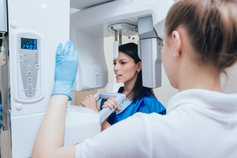 Employee helping patient prepare for dental implants in Huntington Beach.