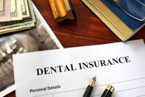 Dental insurance paperwork on desk with X-ray