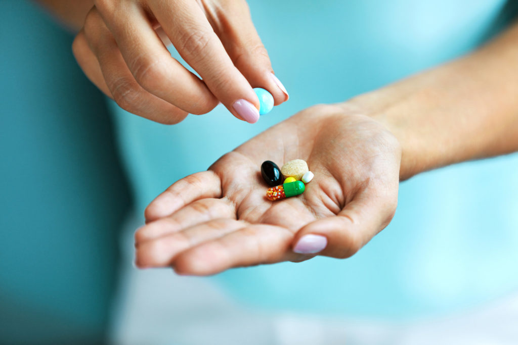 person taking vitamins to prevent gum disease in Huntington Beach