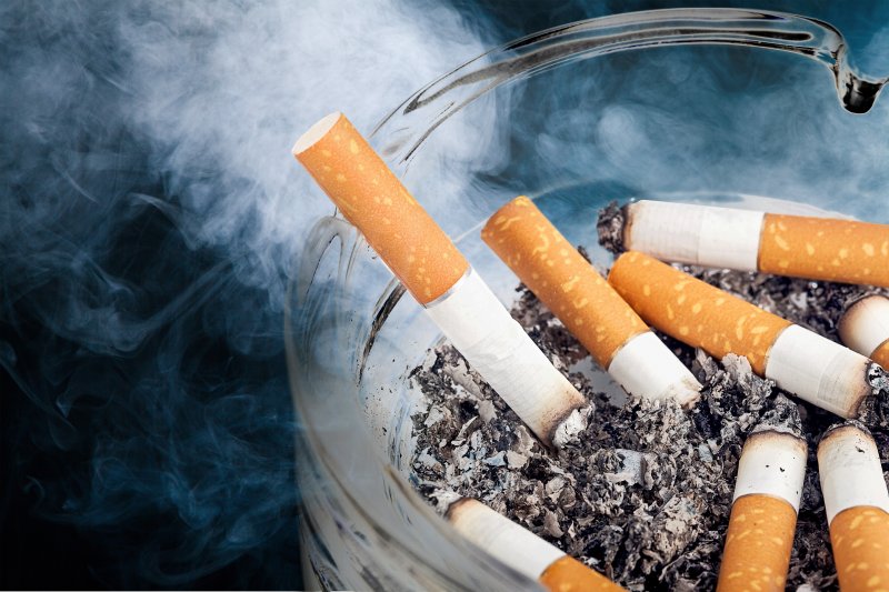 Bowl of cigarettes that harm dental implants in Huntington Beach