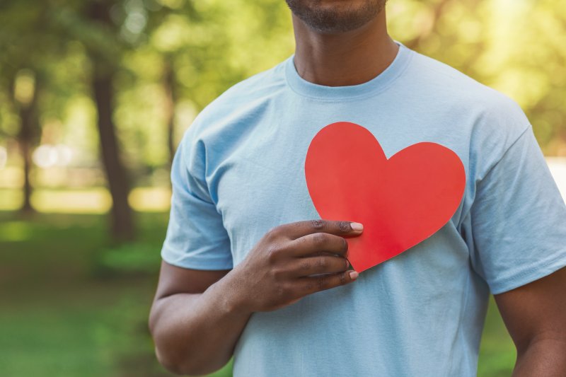 Man holding paper heart for Heart Health Month