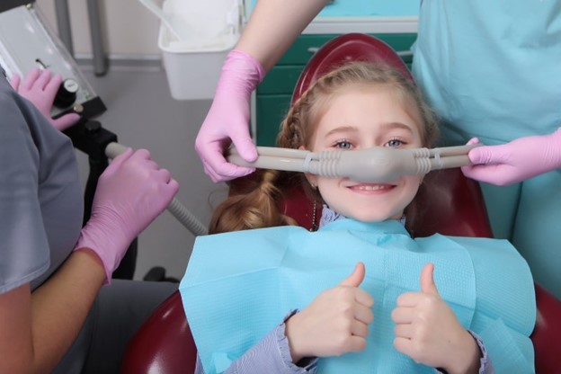 Young girl at dentist receiving sedation dentistry.