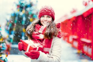 Woman in winter clothing holding a gift