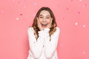 a woman smiling with healthy teeth and gums during 2023