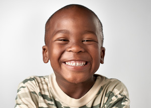 Close-up of a child in a camo shirt smiling