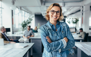 Woman in a denim jacket smiling in an office