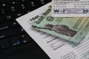 a tax refund check and a W-2 laying on a computer keyboard