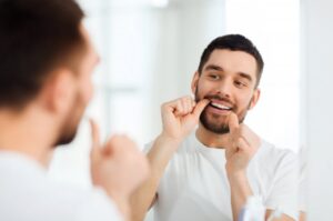 Man taking care of his gums by flossing