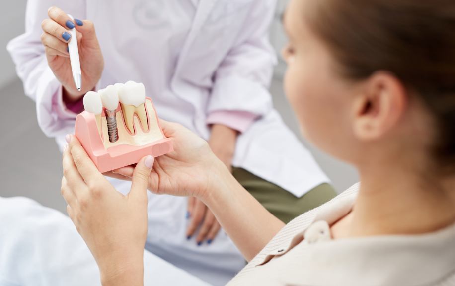 Dentist showing patient model of a dental implant